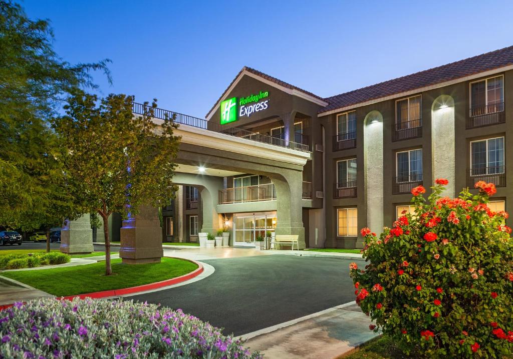 a hotel building with a parking lot and flowers at Holiday Inn Express Lancaster, an IHG Hotel in Lancaster