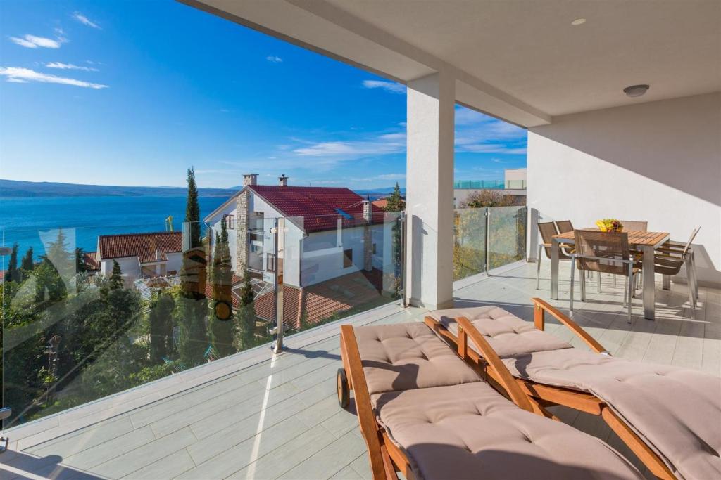 a balcony with chairs and a view of the water at WHITE HOUSE PENTHOUSE in Dramalj