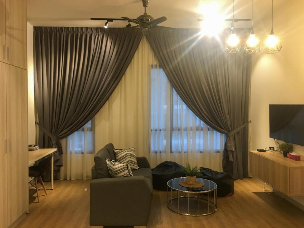 - un salon avec un canapé et une table dans l'établissement Zayah Homestudio near Bukit Jalil / Mines, à Seri Kembangan