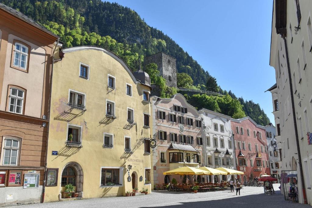 a group of buildings on a street with a mountain at Haus Schlosskeller in Rattenberg