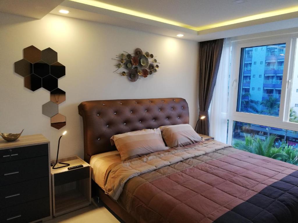 a bedroom with a bed and a large window at Grand Avenue Residence 1 bedroom in Pattaya Central