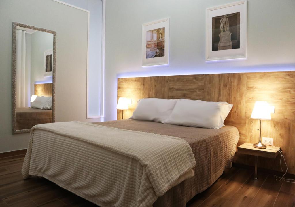 a bedroom with a bed with two lamps and a mirror at Residenza La Reggia in Caserta