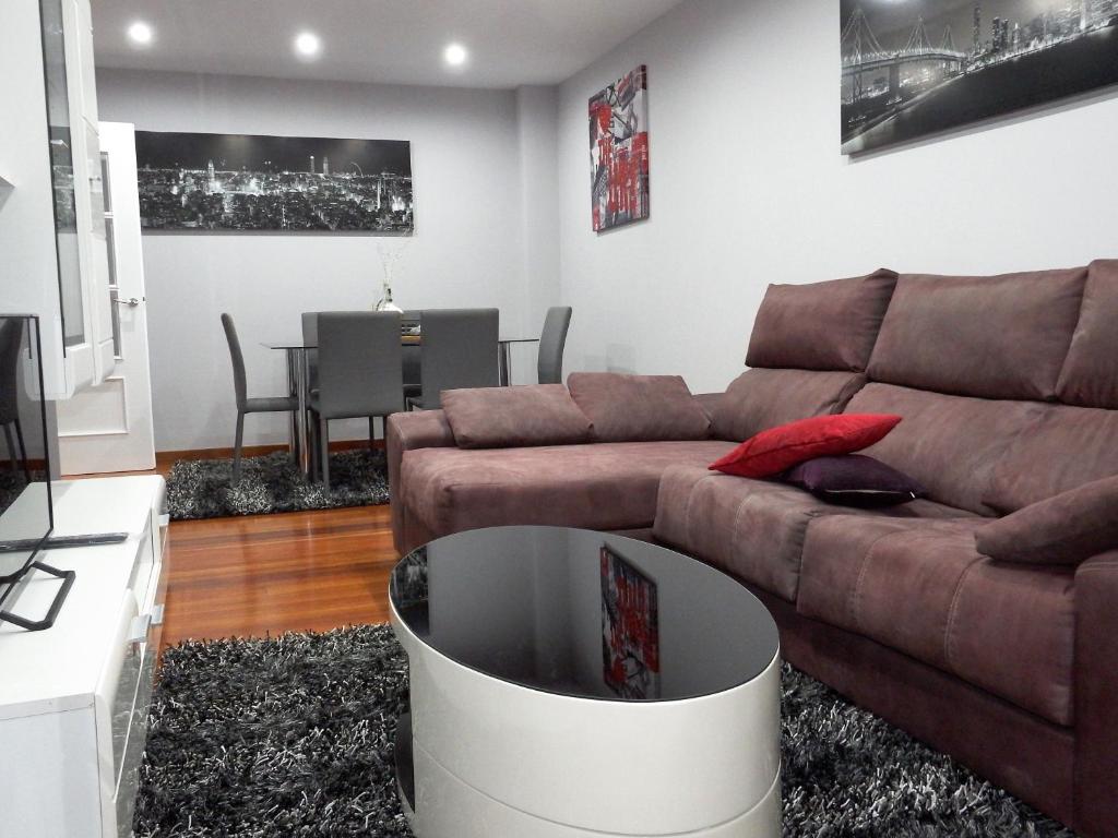 sala de estar con sofá marrón y mesa en Pardal12 By Vigovacaciones, en Vigo