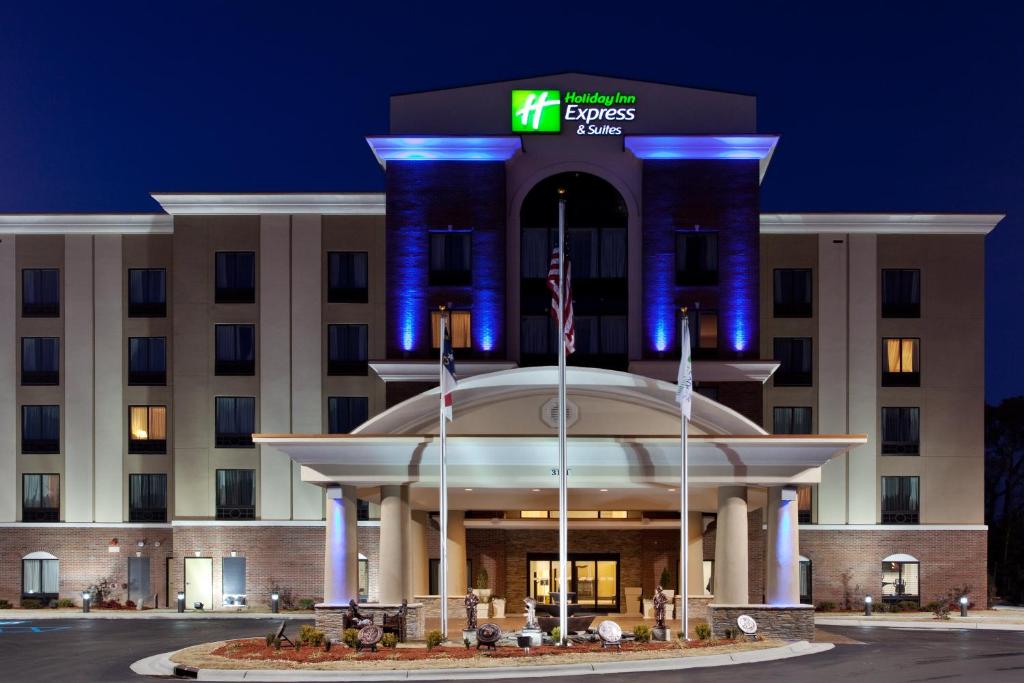 un hotel frente a un edificio por la noche en Holiday Inn Express Hotel & Suites Hope Mills-Fayetteville Airport, an IHG Hotel en Hope Mills