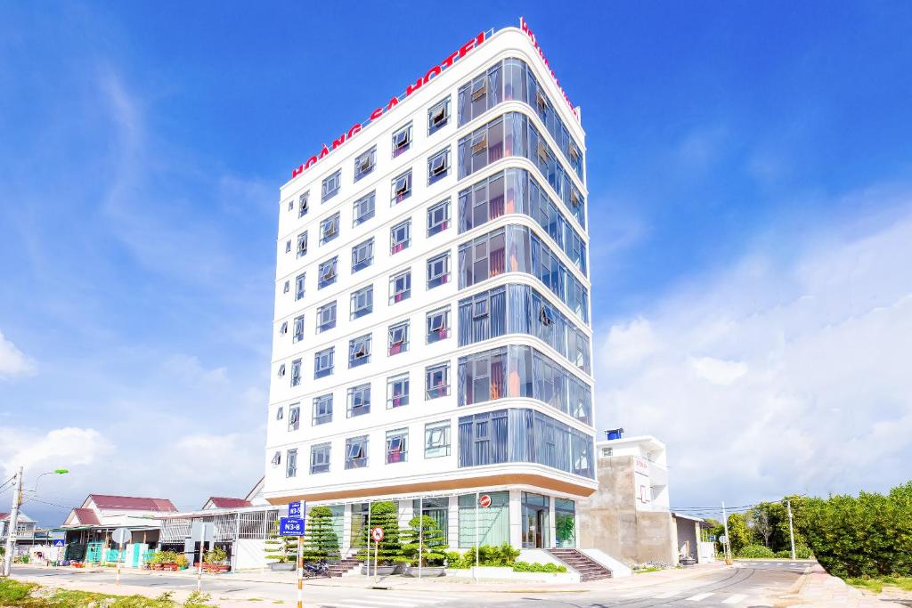 金蘭的住宿－Hoang Sa Bai Dai Hotel，上面有红色标志的高大的白色建筑