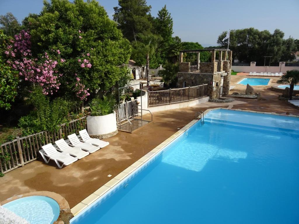 una piscina con 2 tumbonas y una piscina en Camping Via Romana, en Prunelli-di-Fiumorbo