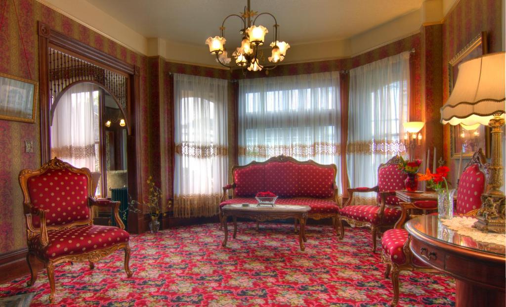 a living room with red furniture and a chandelier at Gingerbread Mansion in Ferndale