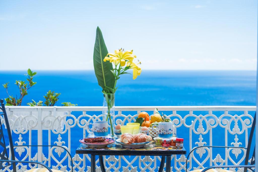 una bandeja de comida en una mesa en un balcón en Casa Nilde en Positano