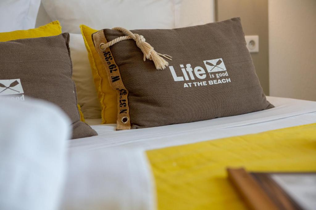 - un lit avec un oreiller donnant vie à la plage dans l&#39;établissement Hôtel Le Vert Bois, à Dolus-d&#39;Oléron
