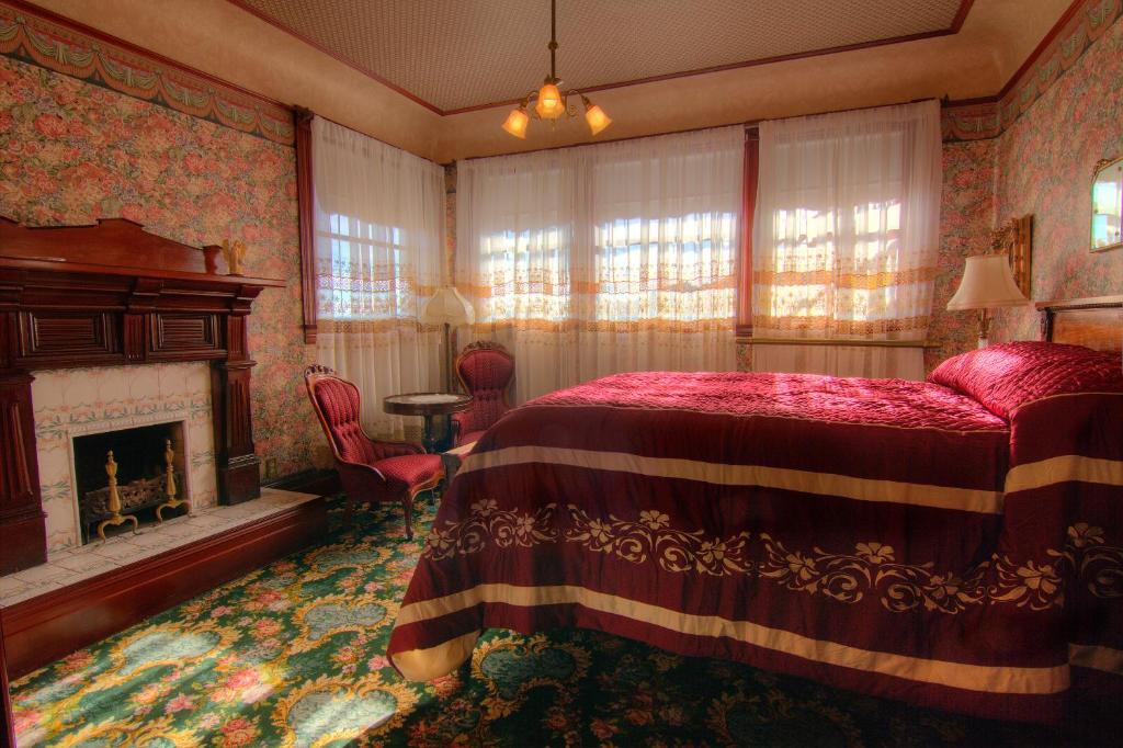a bedroom with a bed and a fireplace at Gingerbread Mansion in Ferndale