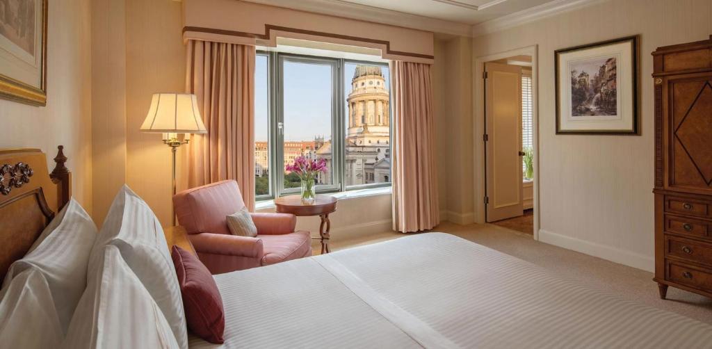 a bedroom with a bed and a chair and a window at Regent Berlin, an IHG Hotel in Berlin