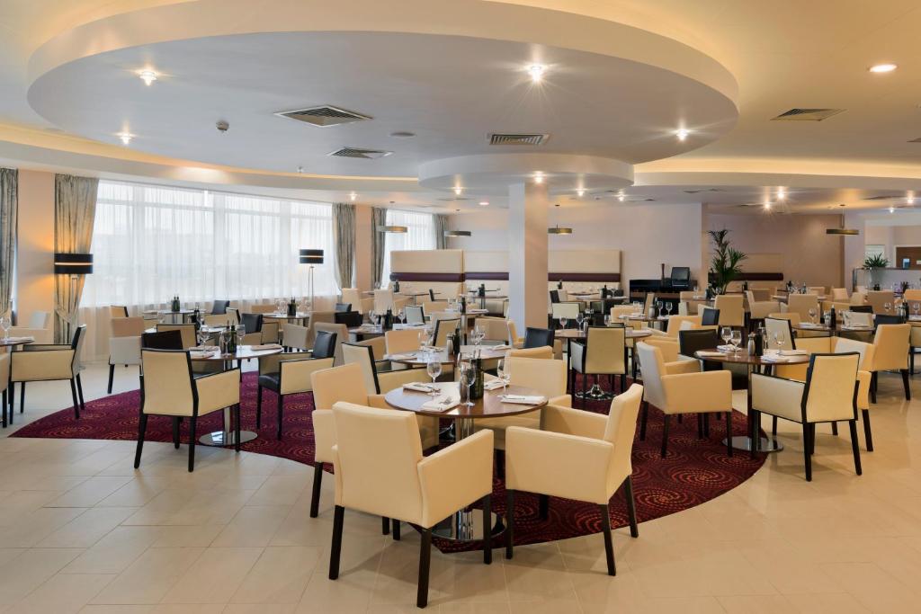 un gran comedor con mesas y sillas en Holiday Inn Derby Riverlights, an IHG Hotel, en Derby