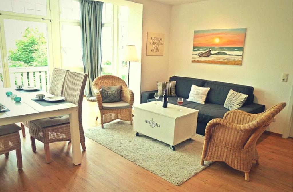 ein Wohnzimmer mit einem Sofa, Stühlen und einem Tisch in der Unterkunft Ferienwohnung Beach Loft im Haus Kühlung in Kühlungsborn