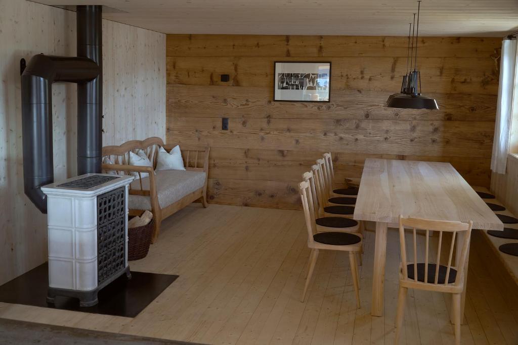 een eetkamer met een tafel en stoelen en een bank bij UNSER VORSÄSS - Geißkopf in Schwarzenberg im Bregenzerwald