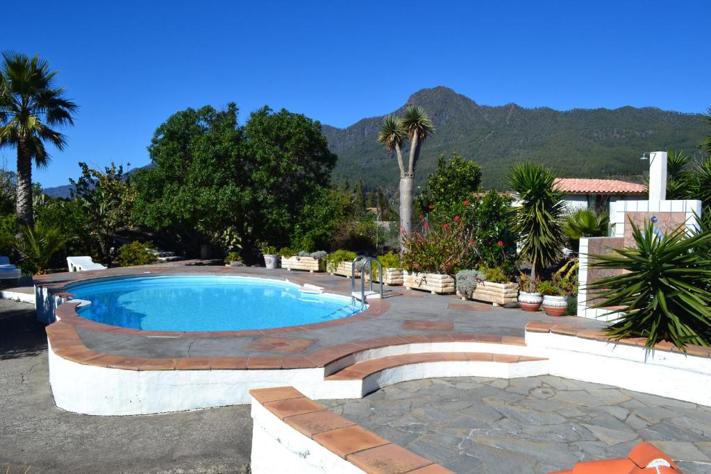Una piscina con una pasarela de ladrillos a su alrededor. en Finca Primavera, en El Paso