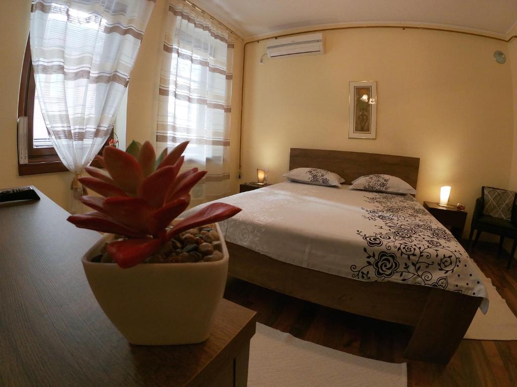 1 dormitorio con 1 cama y una maceta en Apartment Honey Free Parking en Sarajevo