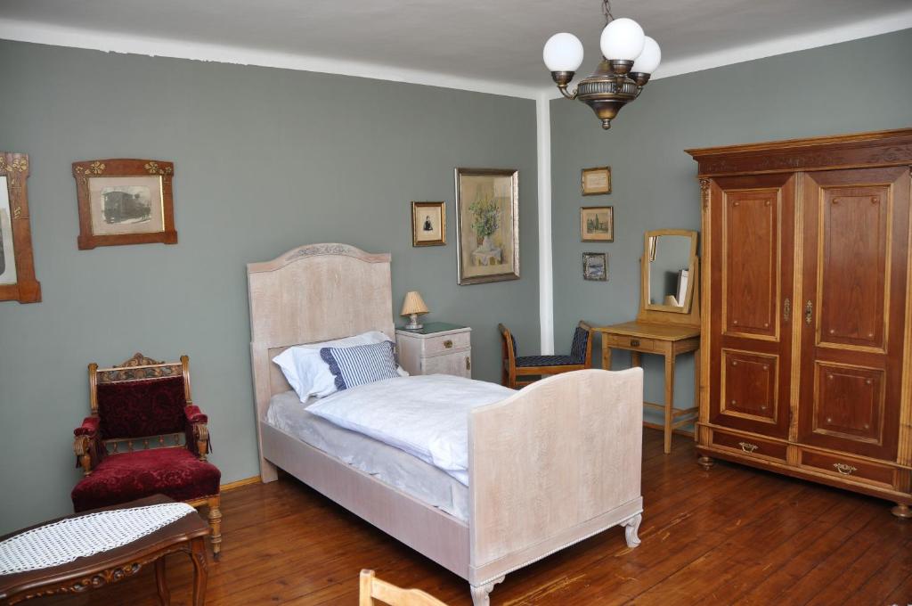 ein Schlafzimmer mit einem Bett, einer Kommode und einem Stuhl in der Unterkunft Penzion Leticia in Strakonice