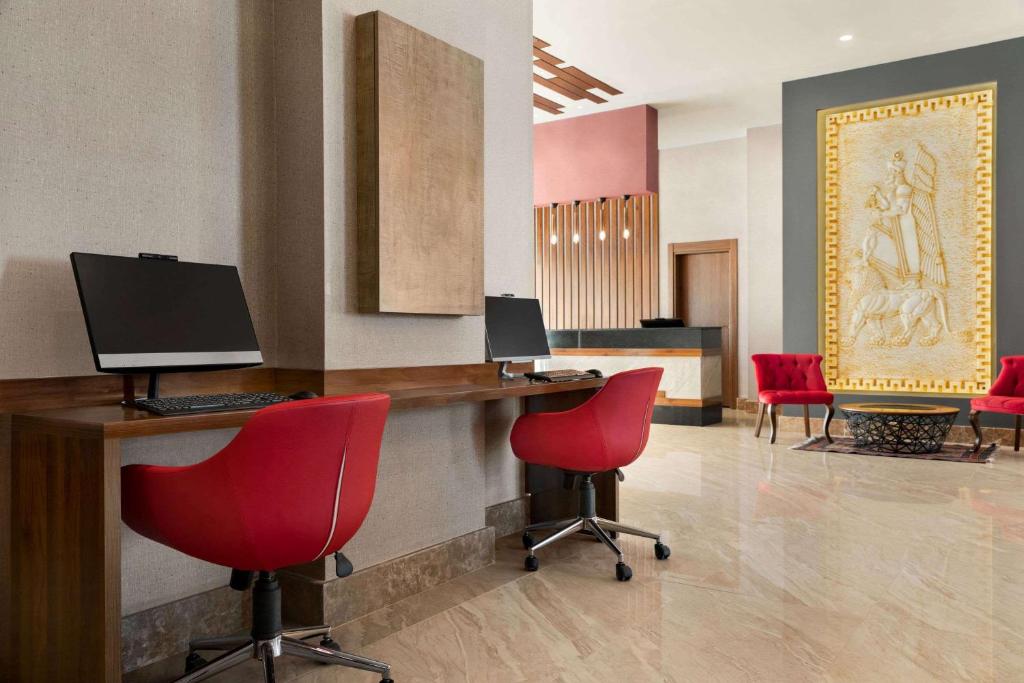 a lobby with red chairs and a desk with a computer at Ramada by Wyndham Van in Van