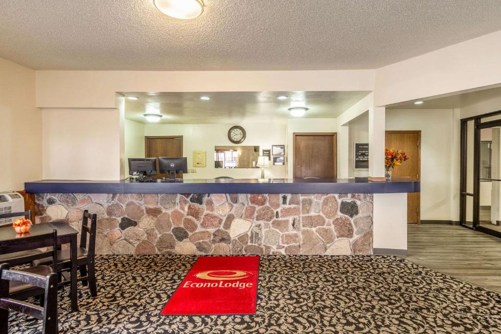 a hotel lobby with a bar with a table and chairs at Econo Lodge Waupaca in Waupaca