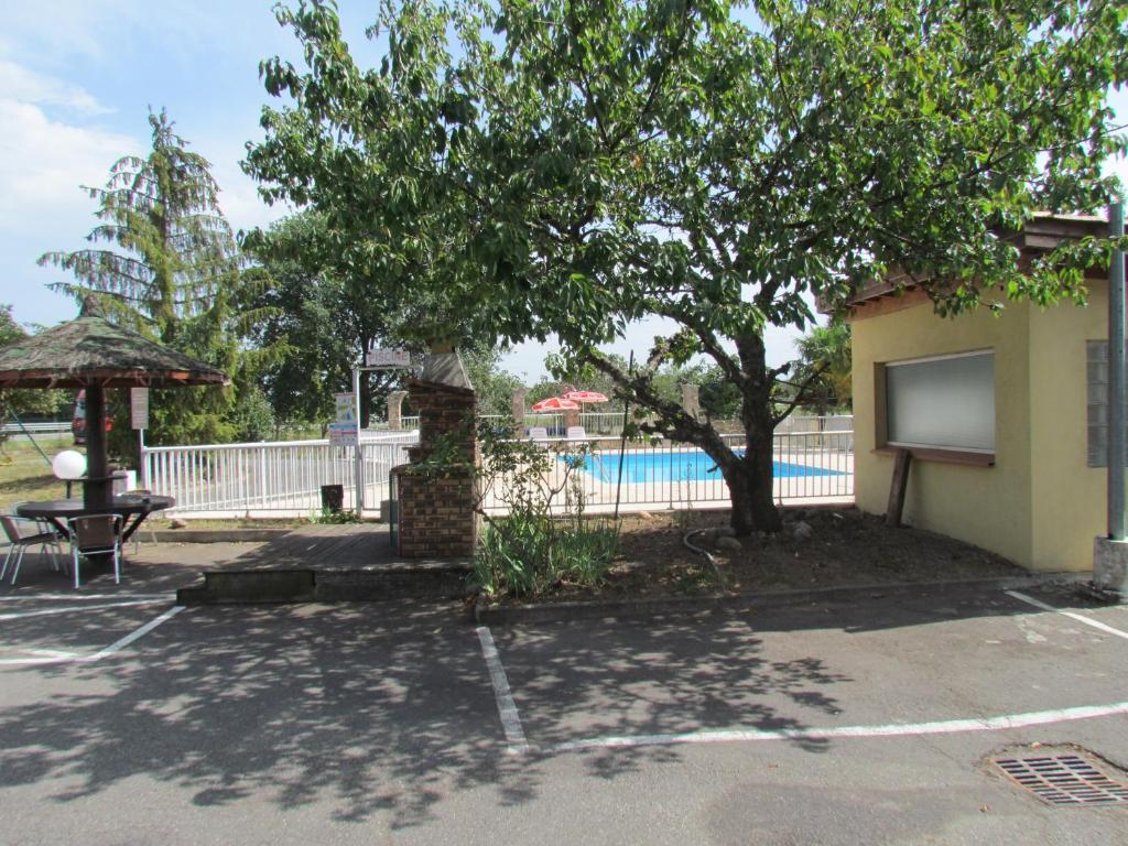 a building with a tree and a swimming pool at Dortoirs Rocade 2 in Pamiers