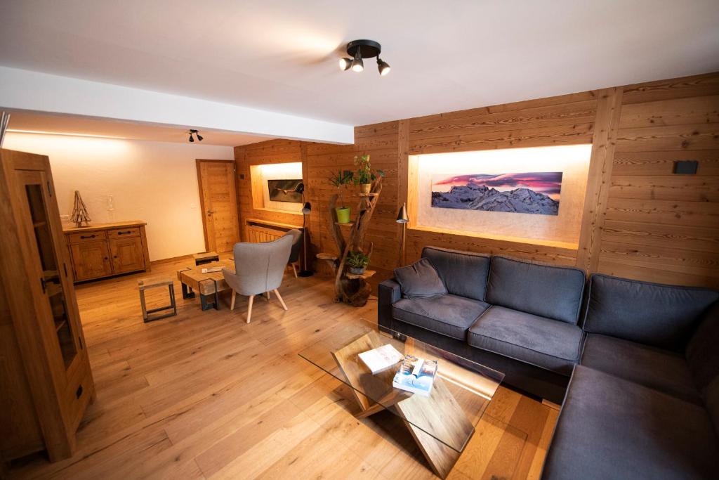 ein Wohnzimmer mit einem Sofa und einem Tisch in der Unterkunft Hotel Les Chamois in Verbier