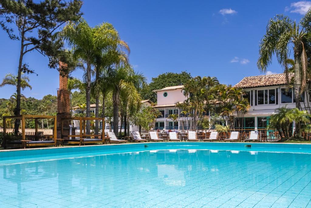 una piscina di fronte a un edificio con palme di Selina Floripa a Florianópolis