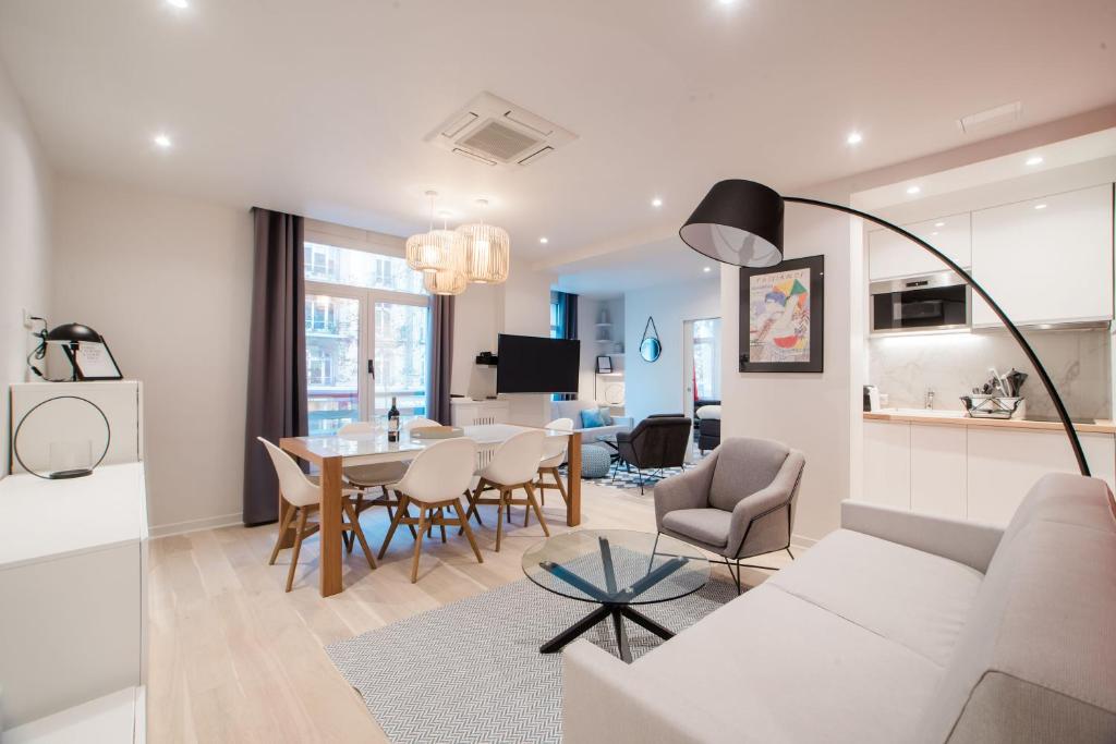 un salon avec un canapé blanc et une table dans l'établissement SUITE COCTEAU : au cœur de la Rive Gauche, neuf, design, 2/4/6 personnes, à Paris