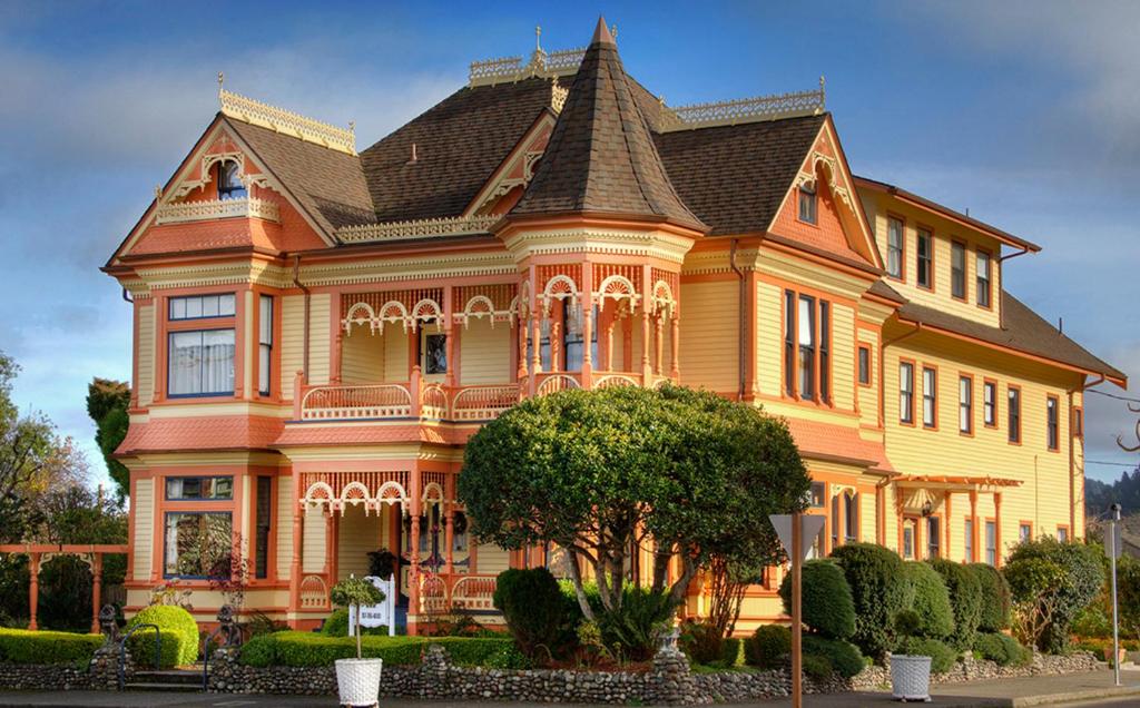 een groot geel en oranje huis met een dak bij Gingerbread Mansion in Ferndale