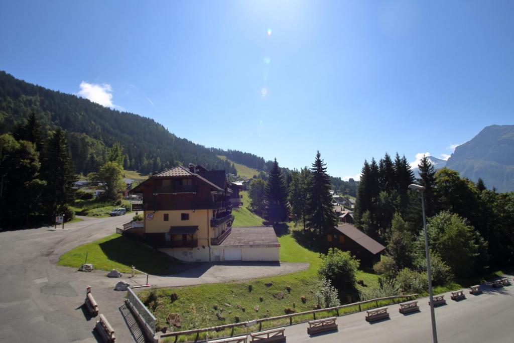 un bâtiment situé sur le côté d'une route à côté d'une montagne dans l'établissement OB222 - 2 pièces Mezzanine 6 pers pieds de pistes, aux Carroz d'Arâches