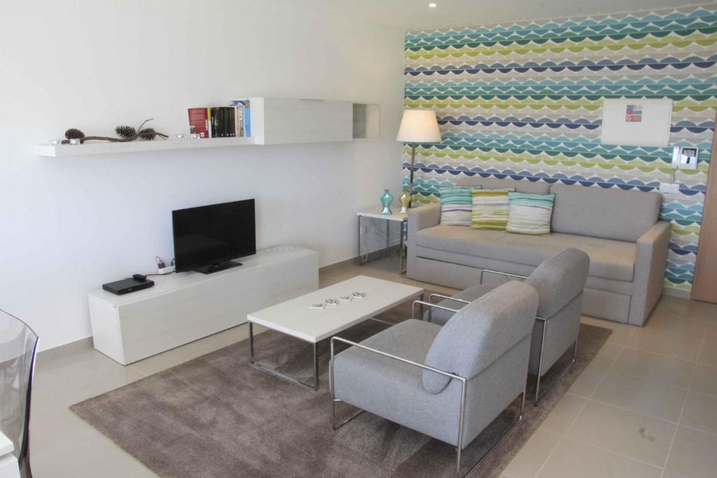 uma sala de estar com um sofá e uma televisão em Carmona - Holiday Apartments - By SCH em São Martinho do Porto