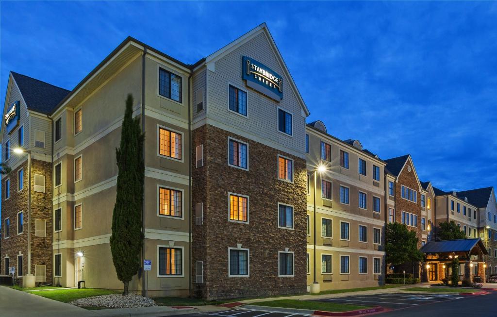 un bâtiment d'hôtel avec un panneau sur son côté dans l'établissement Staybridge Suites Austin Round Rock, an IHG Hotel, à Round Rock