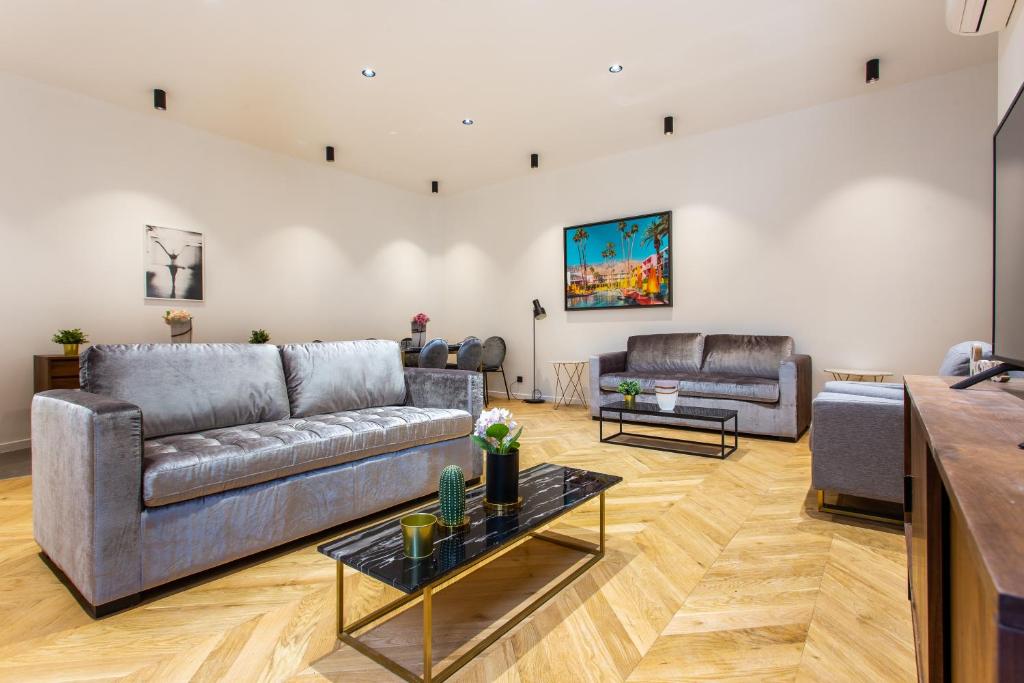 ein Wohnzimmer mit 2 Sofas und einem Tisch in der Unterkunft CMG Champs Elysées - Boetie 7 in Paris