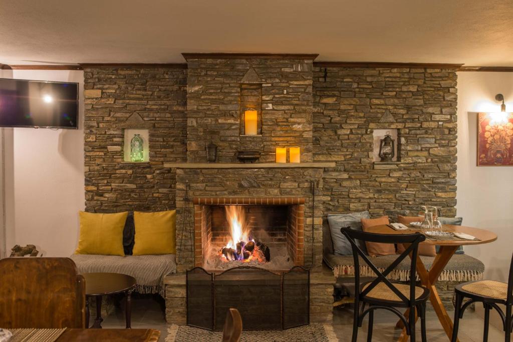 een woonkamer met een open haard en een bank bij Charis Guesthouse in Makrinítsa