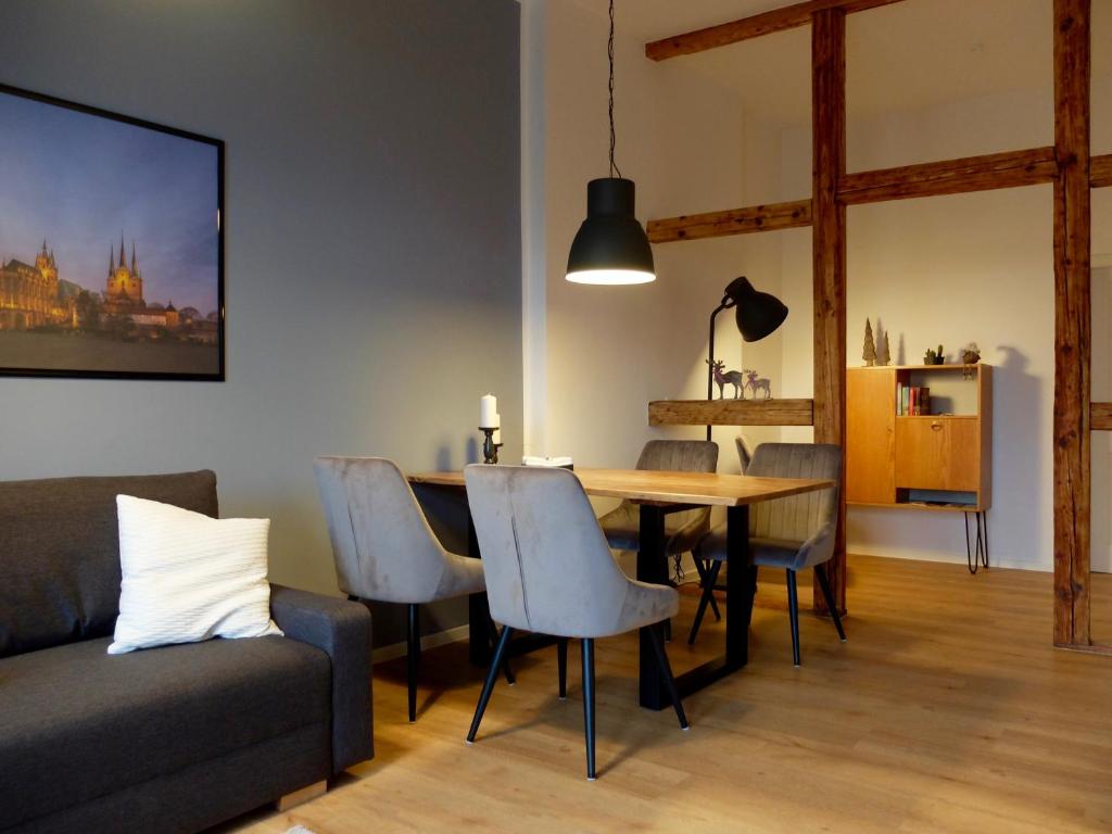 a living room with a table and chairs and a couch at Altstadt Apartment Erfurt in Erfurt