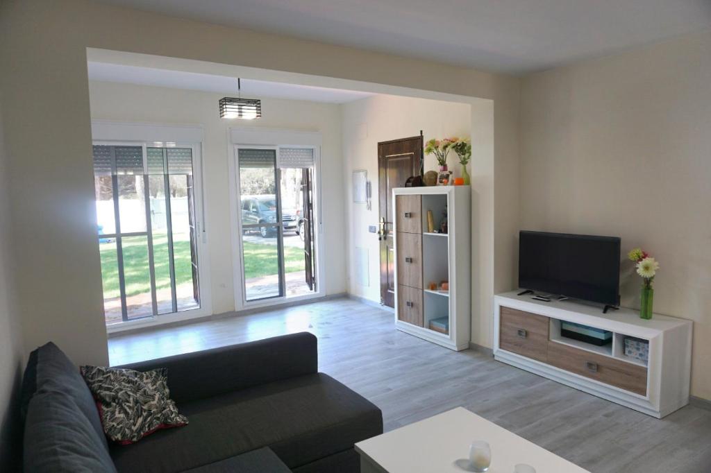 salon z kanapą i telewizorem z płaskim ekranem w obiekcie Relax y playa en la Barrosa w mieście Chiclana de la Frontera
