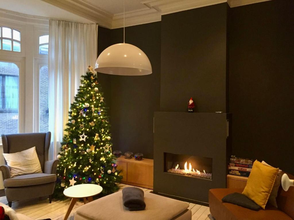 a living room with a christmas tree and a fireplace at Uniek Art Deco Herenhuis in Ostend