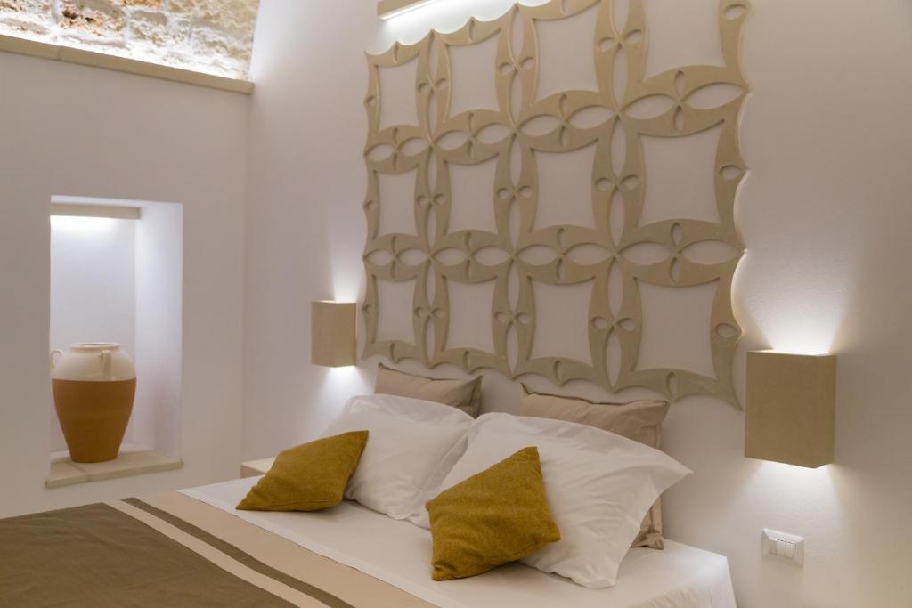 Casa Litarà في كوتروفيانو: غرفة نوم بسرير ذو شراشف بيضاء ومخدات صفراء