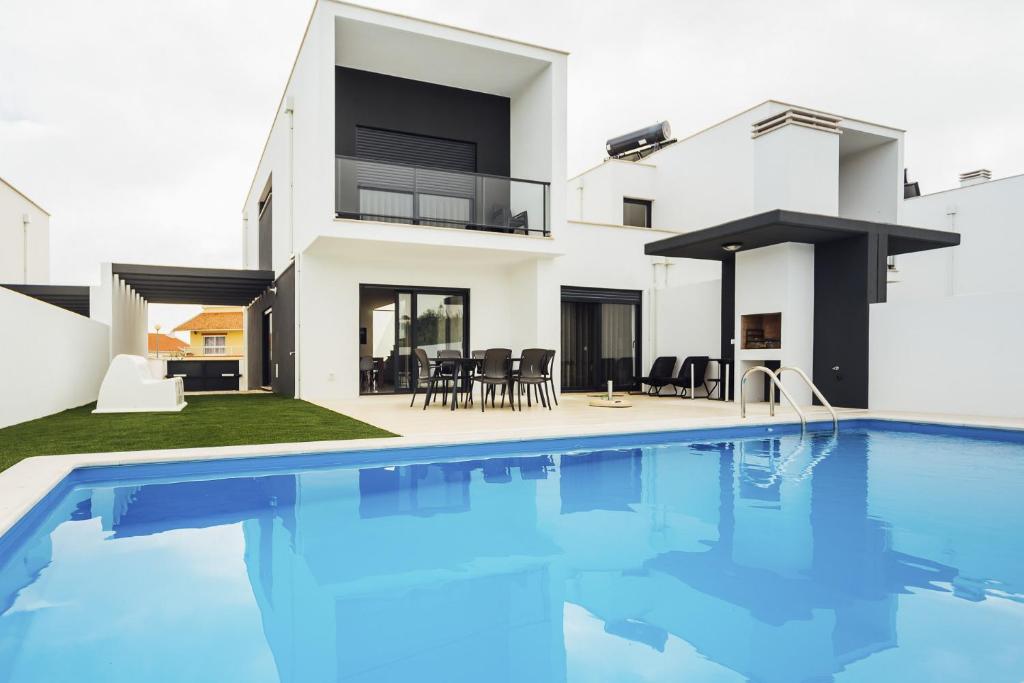 a villa with a swimming pool in front of a house at Estrela de Salir - Holiday - By SCH in Salir de Porto
