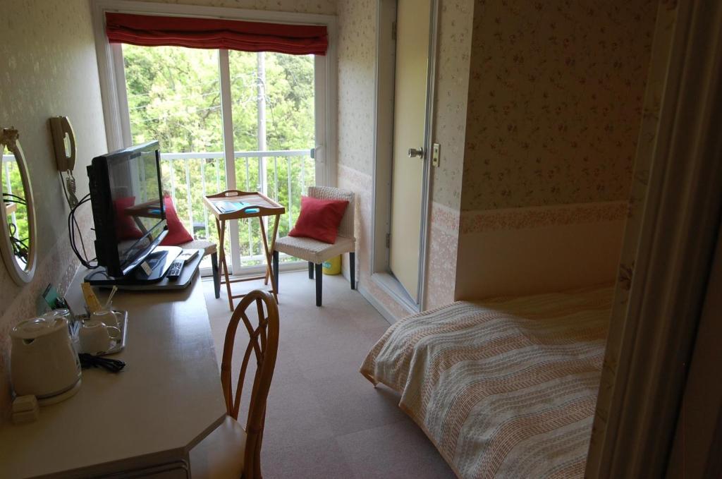 sypialnia z łóżkiem, telewizorem i oknem w obiekcie Ito - Hotel / Vacation STAY 64402 w mieście Ito
