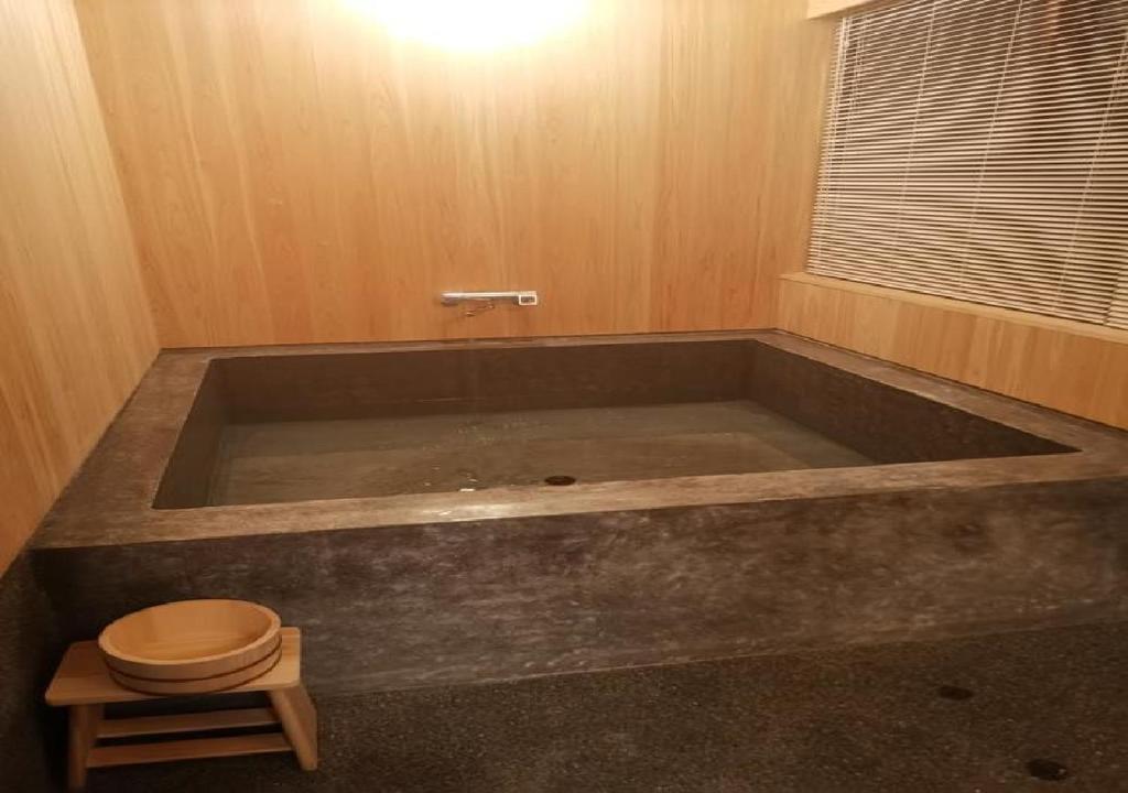 a large bath tub in a room with a toilet at Setouchi Cominca Stays Hiroshima furousen / Vacation STAY 64497 in Shōbara