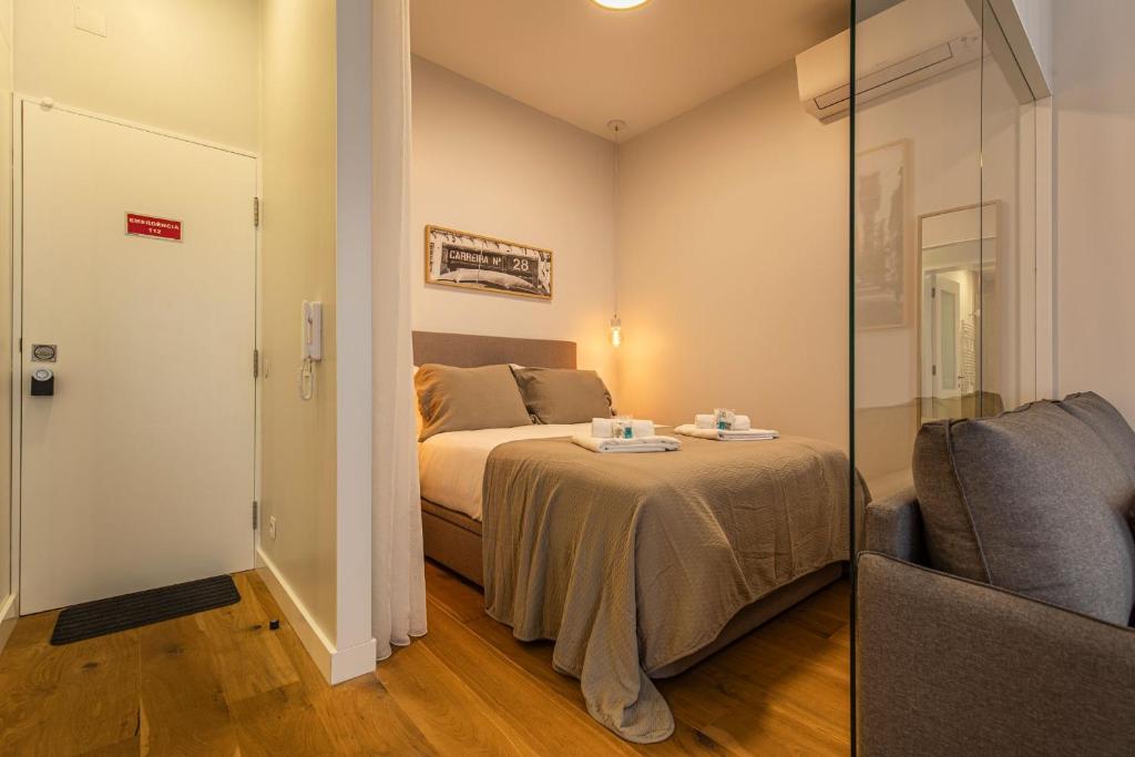 ein kleines Schlafzimmer mit einem Bett und einem Stuhl in der Unterkunft Upscale & Trendy flat in the Center in Lissabon