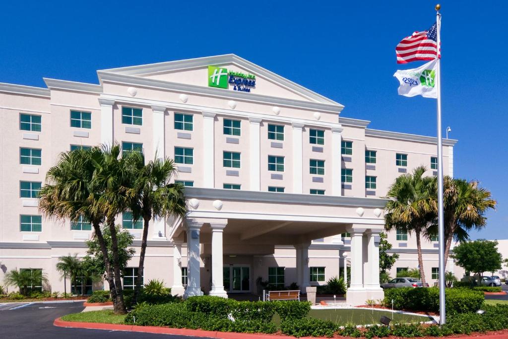 un edificio de oficinas con una bandera delante de él en Holiday Inn Express & Suites Miami Kendall, an IHG Hotel, en Kendall