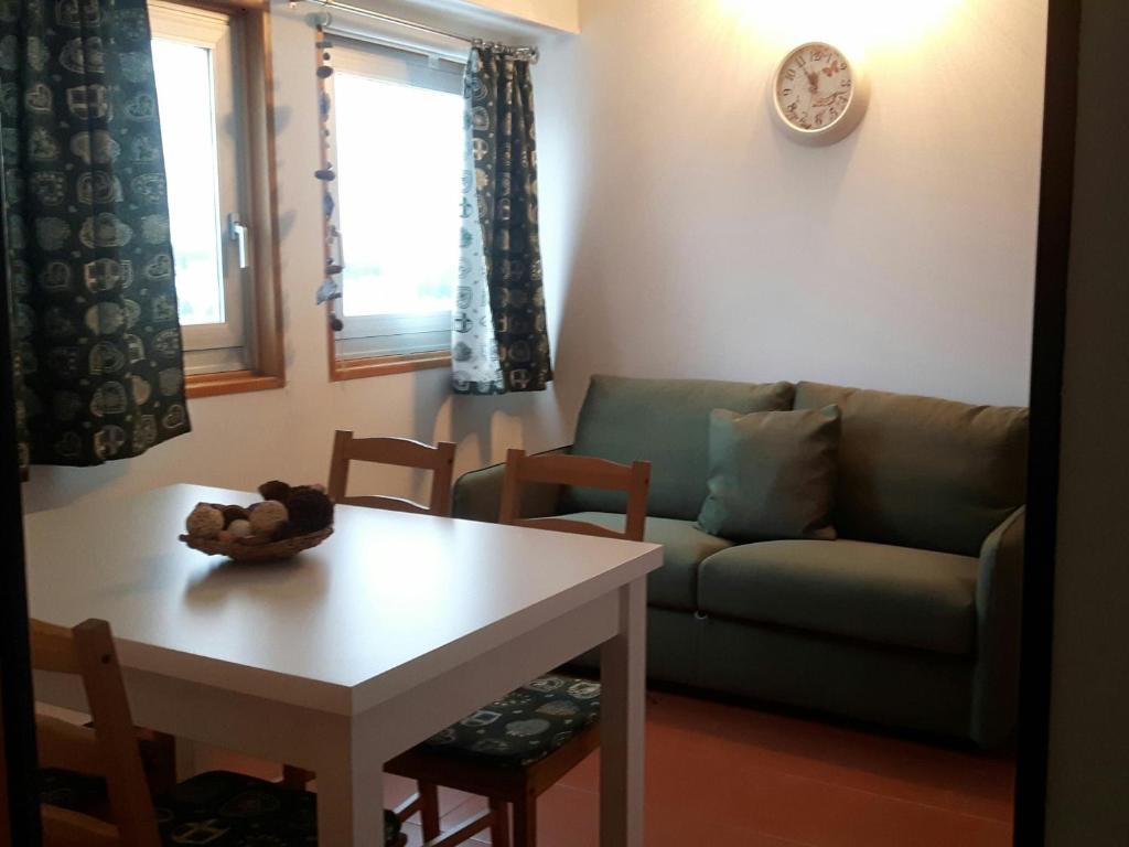 salon z kanapą i stołem w obiekcie Appartamento San Bartolomeo w mieście Passo del Tonale