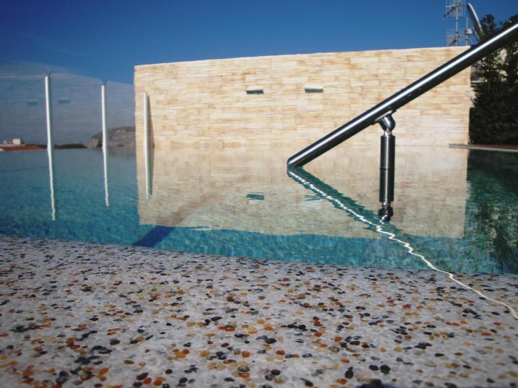 a pool of water with a metal railing next to a building at Hotel Plaza in Sorrento