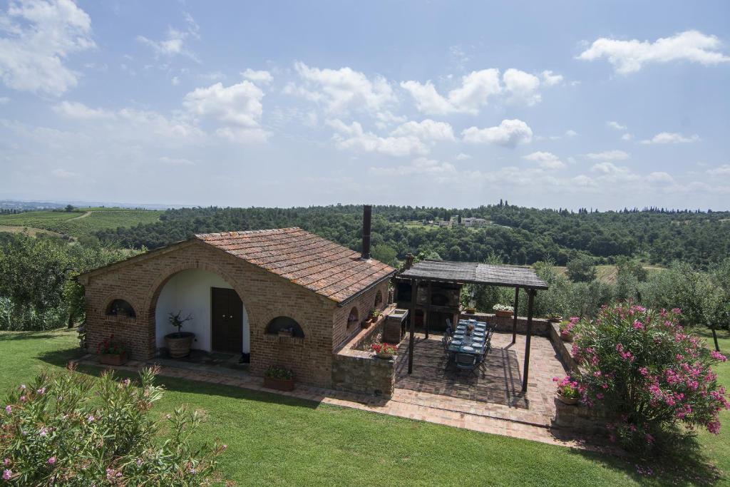 un pequeño edificio de ladrillo en un campo de hierba en Cottage Le Pozze, en Sinalunga