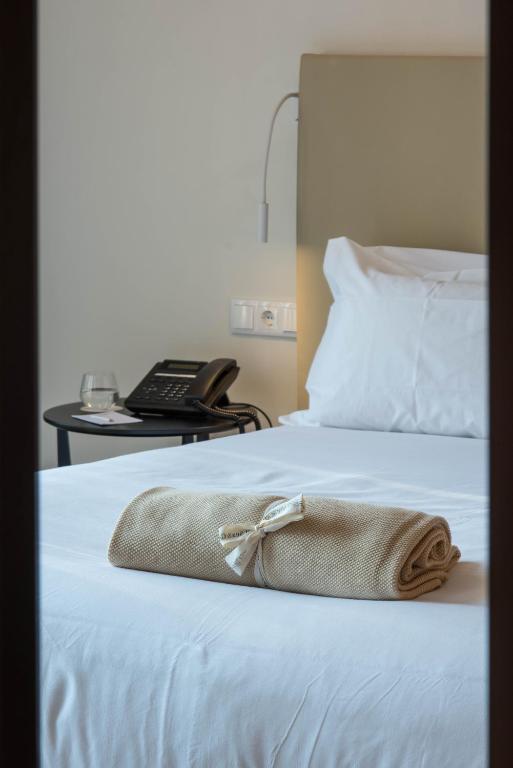 a purse sitting on top of a bed with a phone at Aroeira Lisbon Hotel - Sea & Golf in Aroeira