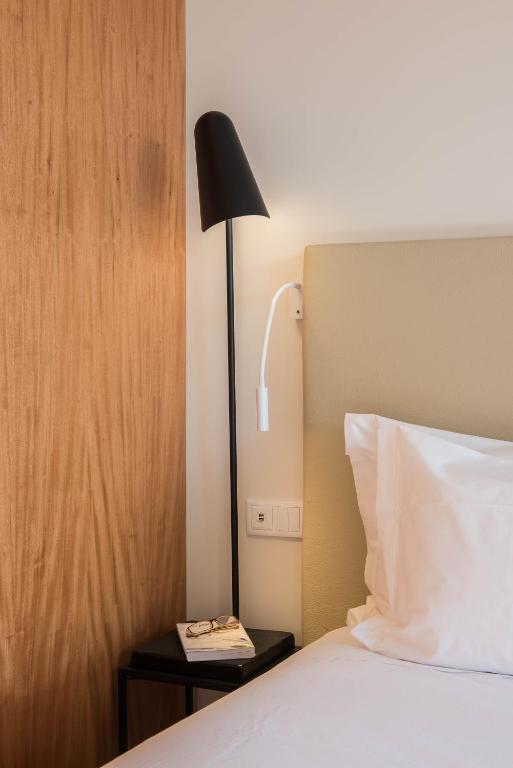 a lamp on a nightstand next to a bed at Aroeira Lisbon Hotel - Sea & Golf in Aroeira