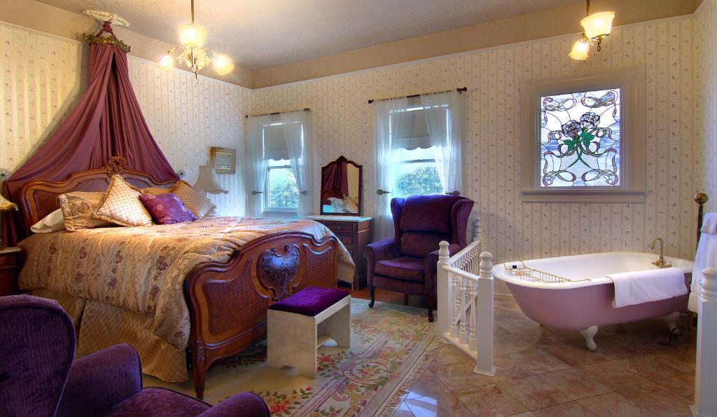 a bedroom with a bed and a bath tub and a tub at Gingerbread Mansion in Ferndale