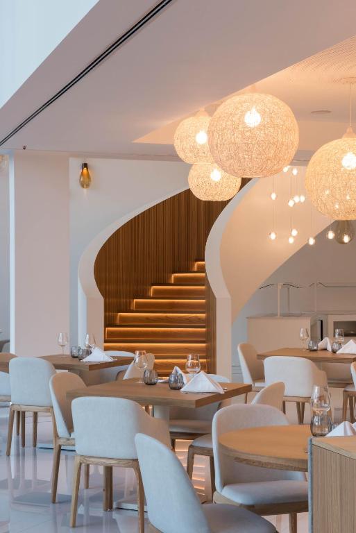 a restaurant with tables and chairs and a staircase at Aroeira Lisbon Hotel - Sea & Golf in Aroeira