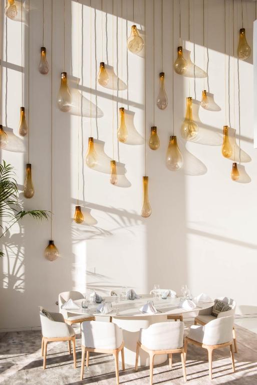 a dining room with tables and chairs and lights at Aroeira Lisbon Hotel - Sea & Golf in Aroeira